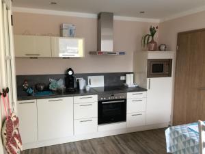 a kitchen with white cabinets and a microwave at Feriendomizil strasser in Homburg