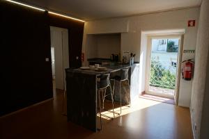 a kitchen with a black counter top and a window at ribeira dos marinheiros amarelo in Sintra