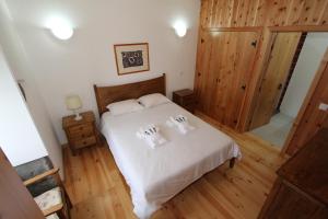 a bedroom with a bed with two towels on it at Casa Branca do Imperio in Cinco Ribeiras