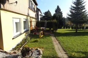 a house with a grass yard next to a building at Haus am Waldesrand in Tanne