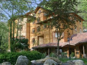 ein großes Backsteingebäude mit einem Baum davor in der Unterkunft Yazicilar Hotel in Masukiye