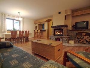 een woonkamer met een open haard en een tafel en stoelen bij Willa Kanada in Zakopane