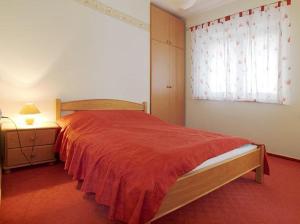 sypialnia z łóżkiem z czerwoną narzutą i oknem w obiekcie Willa Kanada w Zakopanem