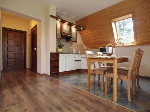 een keuken en eetkamer met een tafel en stoelen bij Willa Kanada in Zakopane