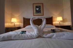 Dos cisnes hechos de toallas en una cama en Casa Branca da Sociedade, en Angra do Heroísmo