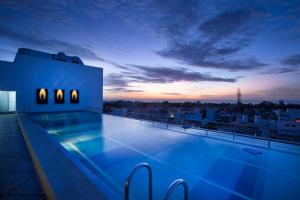 a swimming pool on the roof of a building at Hotel Atithi in Pondicherry