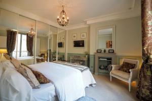 a bedroom with a large white bed and a fireplace at Chambre d hôte : Louvre Elegant Apt Suite in Paris