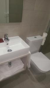 La salle de bains est pourvue d'un lavabo blanc et de toilettes. dans l'établissement El Raco De Navarrete, à Cabanes