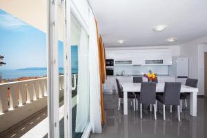 cocina y comedor con mesa y el océano en Villa Ivka, en Makarska