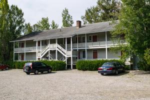 een groot huis met twee auto's geparkeerd op een parkeerplaats bij The Wayside Inn in Bethlehem