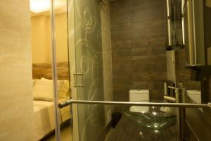 y baño con ducha acristalada y lavamanos. en 212 Hotel, en Santa Rosa de Cabal