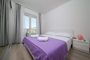 Dormitorio blanco con cama morada y ventana en Villa Ivka, en Makarska 71 fotos más