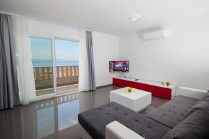 Una sala de estar con un sofá y vista al mar. en Villa Ivka, en Makarska