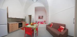 a kitchen and living room with a table and a couch at Eolo Casa Vacanze in Torre Lapillo
