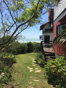 un banco junto a un edificio con el océano en el fondo en Residencial Casa Santinho, en Florianópolis