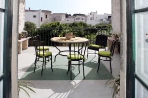 a patio with a table and chairs on a balcony at Residenza Storica PARCO LANOCE in Poggiardo