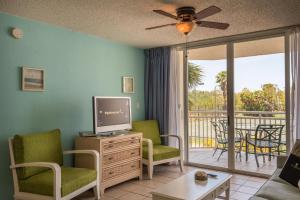 a living room with a television and a balcony at Sunrise Suites Cozumel Suite #112 in Key West