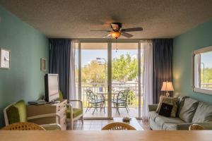 un soggiorno con divano e tavolo con sedie di Sunrise Suites Cozumel Suite #112 a Key West