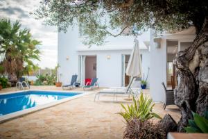 a villa with a swimming pool and a house at Villa Can Massaueta in Sant Jordi