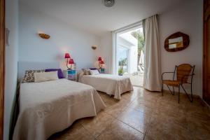 a bedroom with two beds and a window at Villa Can Massaueta in Sant Jordi