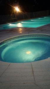 una piscina de agua por la noche con luz de la calle en Ymcamar en Monte Hermoso