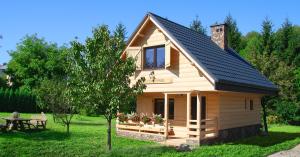 ein kleines Holzhaus mit einem Tisch und einem Baum in der Unterkunft Młynarzowa Chata in Lesko