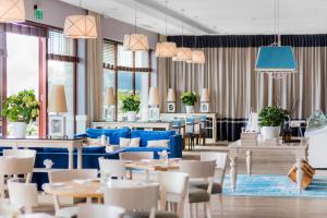 um restaurante com mesas e cadeiras azuis e janelas em Tiffi Boutique Hotel em Olsztyn