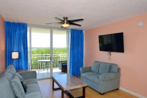 ein Wohnzimmer mit einem Sofa, Stühlen und einem TV in der Unterkunft Sunrise Suites Cayo Coco Suite #208 in Key West