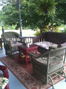 eine Gruppe von Stühlen und Tischen auf einer Terrasse in der Unterkunft Rose & Thistle Bed & Breakfast in Cooperstown