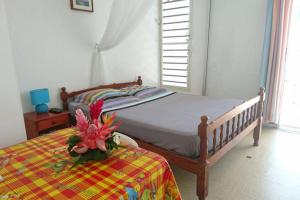 une chambre avec un lit avec une fleur dessus dans l'établissement Location proche plage, au Gosier