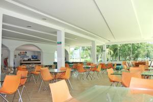 a large room with tables and chairs and windows at Hotel Hacienda Campestre in Melgar