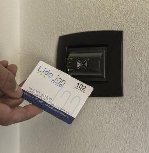 uma pessoa com um cartão de hotel num interruptor de luz em Hotel Lido Inn em Lido di Camaiore