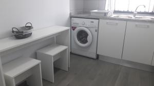 een witte wasruimte met een wasmachine en een wastafel bij AL - BOA NOVA in Madalena