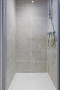 a shower with a glass door in a bathroom at The Apartments in Market Weighton