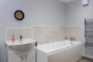 a bathroom with a white tub and a sink and a bath tubermott at The Apartments in Market Weighton