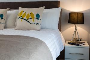 a bed with three yellow birds on the pillows at The Apartments in Market Weighton