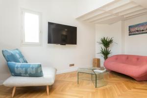 a living room with a couch a chair and a tv at Ateliers de Montmartre ADM in Paris