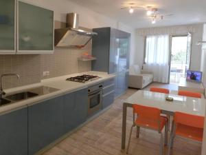 リニャーノ・サッビアドーロにあるSchubertの青いキャビネットとテーブル付きのキッチンが備わります。