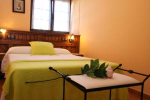 a bedroom with a bed with a yellow blanket and a window at Apartamentos Toraya in Hoz de Anero