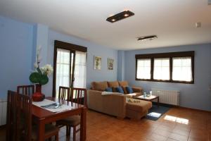 Apartamentos Toraya في Hoz de Anero: غرفة معيشة مع أريكة وطاولة