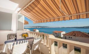 特羅吉爾的住宿－芭芭拉公寓，阳台配有桌椅,享有海景。