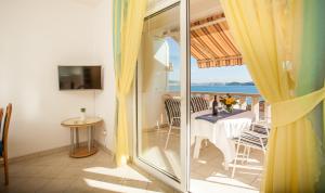 a room with a table and a view of the ocean at Apartments Barbara in Trogir