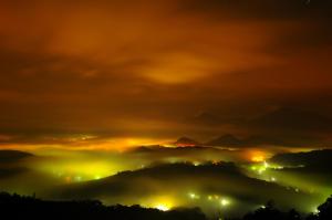 a view of a foggy valley at night at Sun Moon Lake Jinlongshan BnB in Yuchi