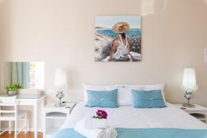 a bedroom with a bed with a painting on the wall at Atlantic Beach Villa in Cape Town