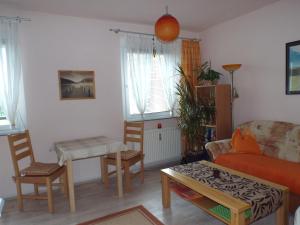 a living room with a couch and a table at 2-Zimmer-Ferienwohnung "Gärten der Welt" in Berlin