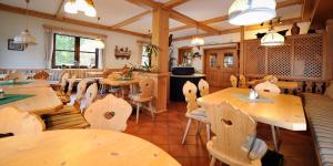 a restaurant with wooden tables and chairs in a room at Kalßwirt in Bad Aussee
