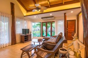 a living room with a couch and a tv at Poonsiri Resort Aonang-SHA Extra Plus in Ao Nang Beach