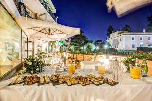 a white table with food and drinks on it at Appia Park Hotel in Rome