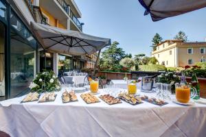 einen Tisch mit Essen und Orangensaft darauf in der Unterkunft Appia Park Hotel in Rom