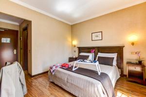 Una habitación de hotel con una cama con una bandeja. en Appia Park Hotel, en Roma